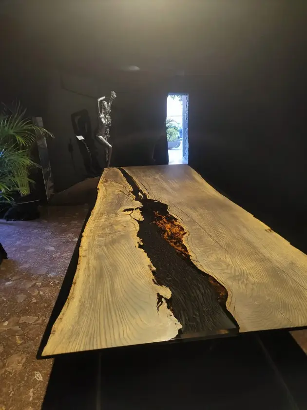 Dreikant Massivholztisch neben einer Kunstskulptur im Pop-up Store Palma