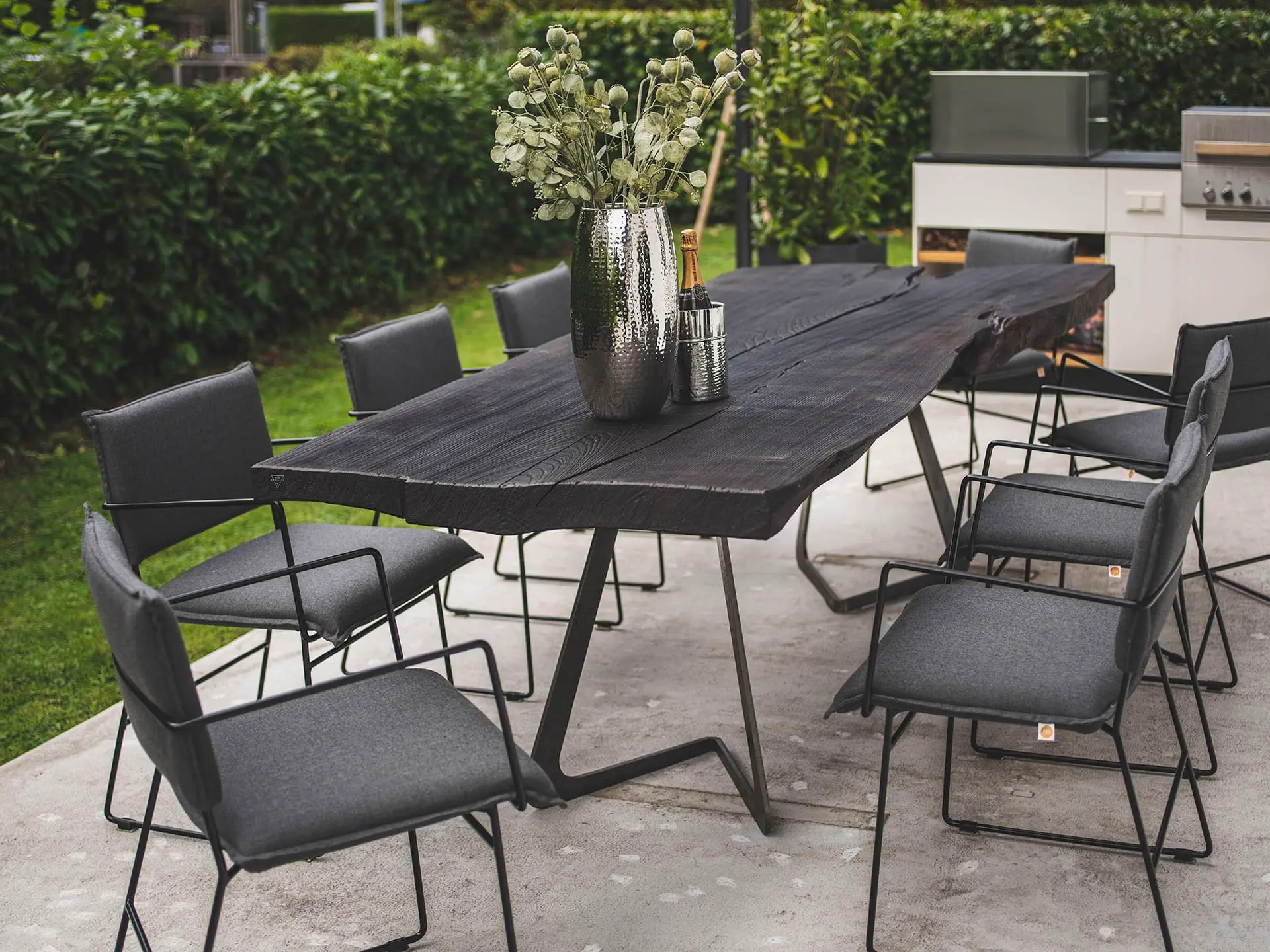 Gemütliche Terrasse mit Dreikant Massivholztisch und komfortablen Möbeln