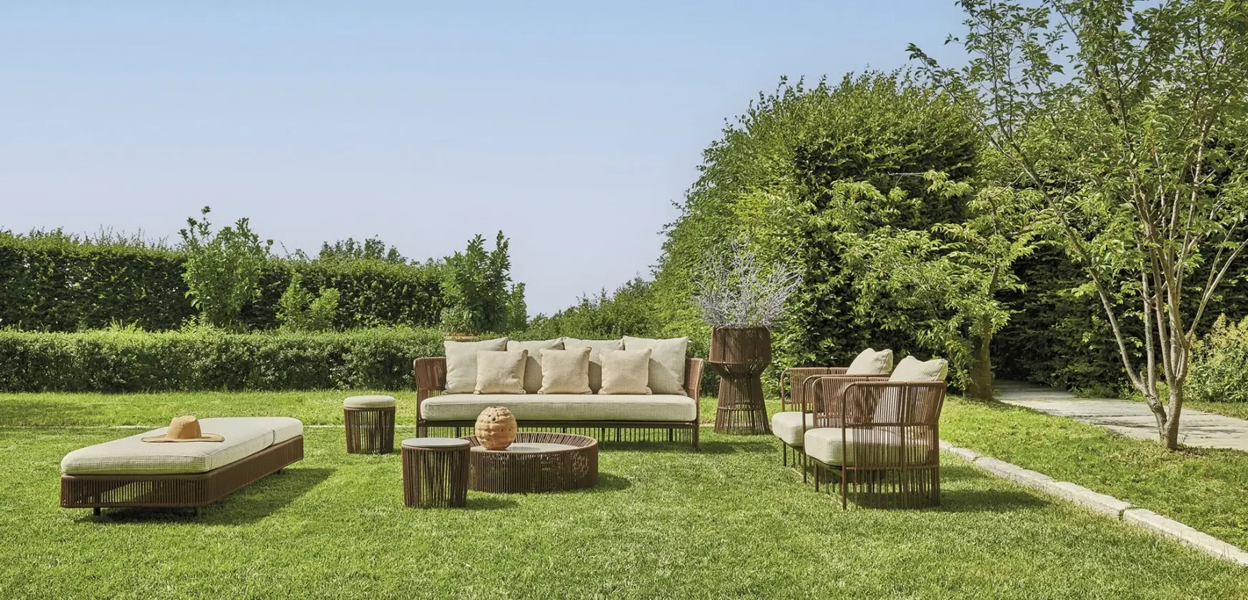 Weiche Textilien und Kissen an einem Dreikant Terrassentisch