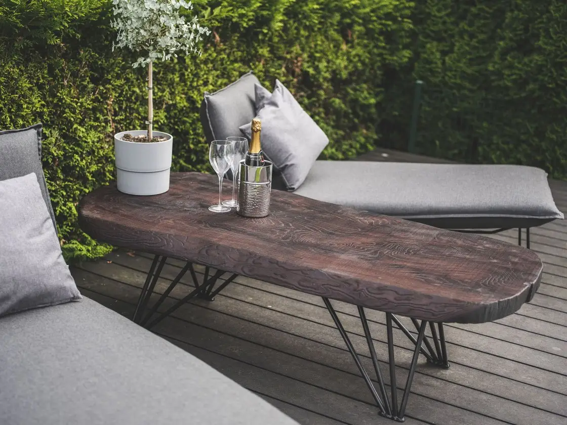 Persönliche Dekoakzente auf einer Terrasse mit Dreikant Massivholztisch