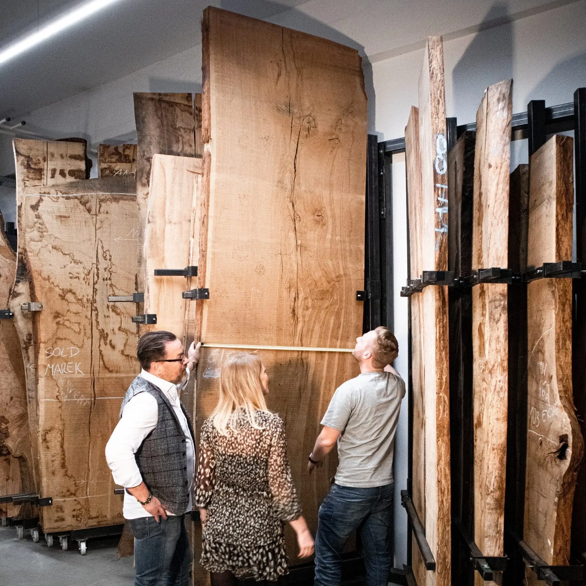 Tischler bei der handwerklichen Fertigung eines Dreikant Baumstammtisches